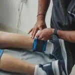 https://www.pexels.com/photo/physiotherapist-standing-over-patient-lying-down-13538710/
